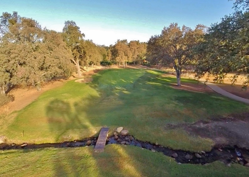 Hole 56 greens with a bridge over a stream