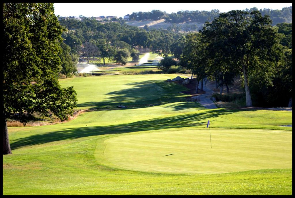 View of course greens with mountains in the background 